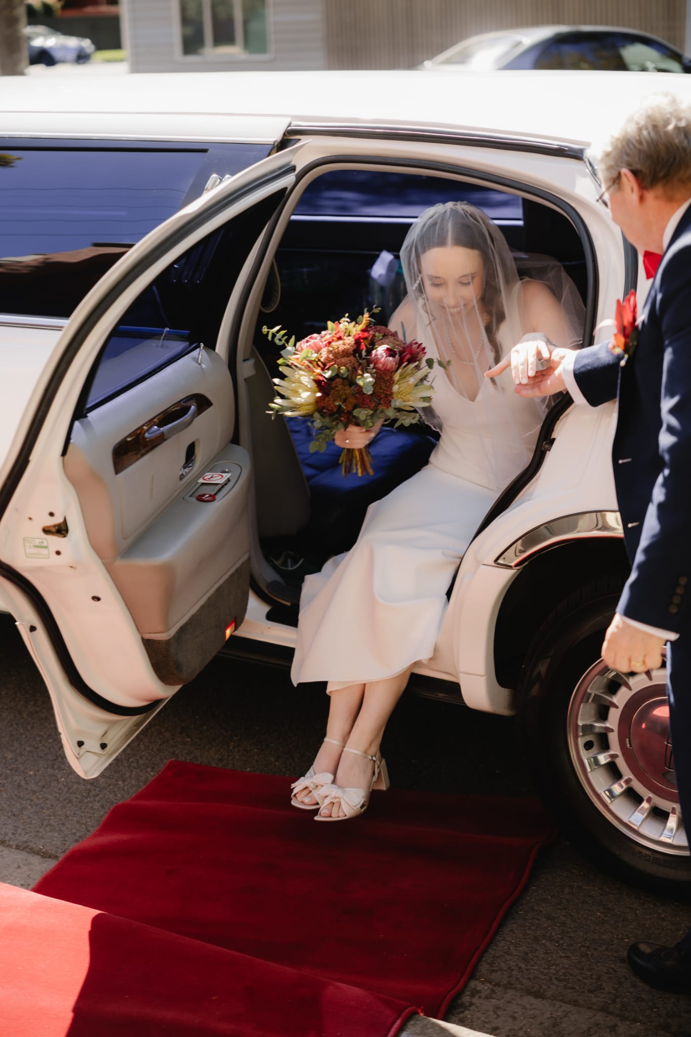 Bride stepping out of the Auslink Limousines Lincoln stretch limousine onto the red carpet in Melbourne
