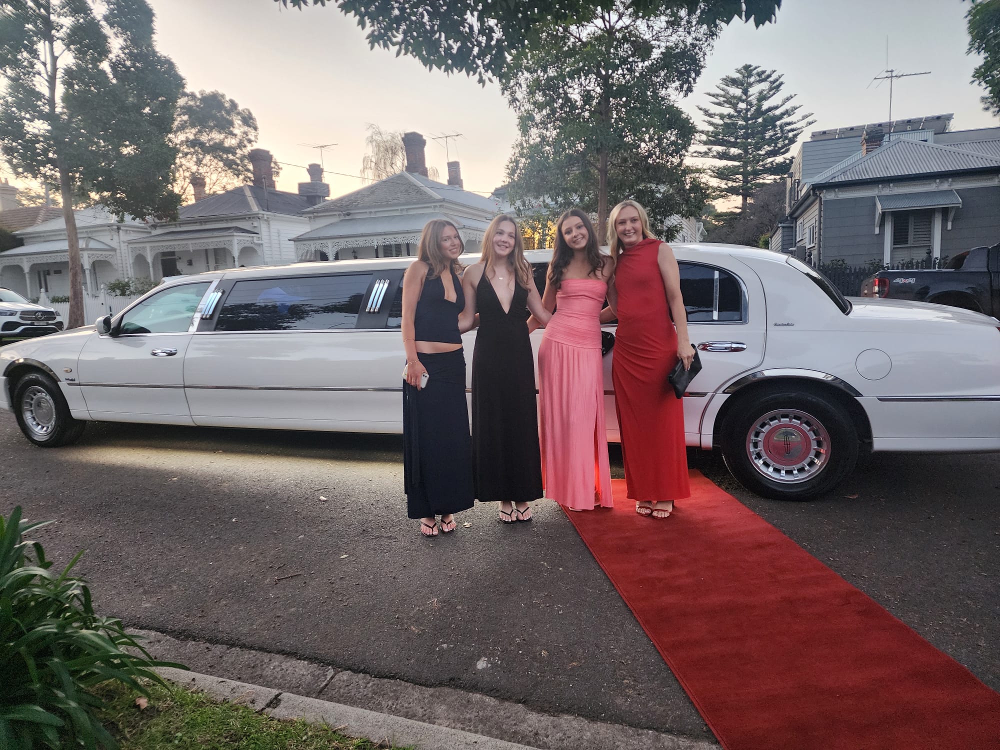 Guests on red carpet beside Auslink white stretch limousine for a Melbourne birthday celebration